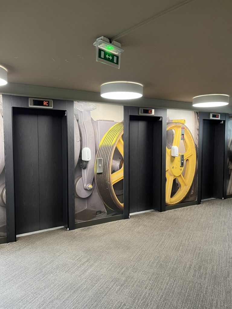 Rénovation avec adhésif effet bois pour l’extérieur et effet tissu pour l’intérieur des ascenseurs de l’hotel IBIS Centre Historique à Strasbourg en Alsace